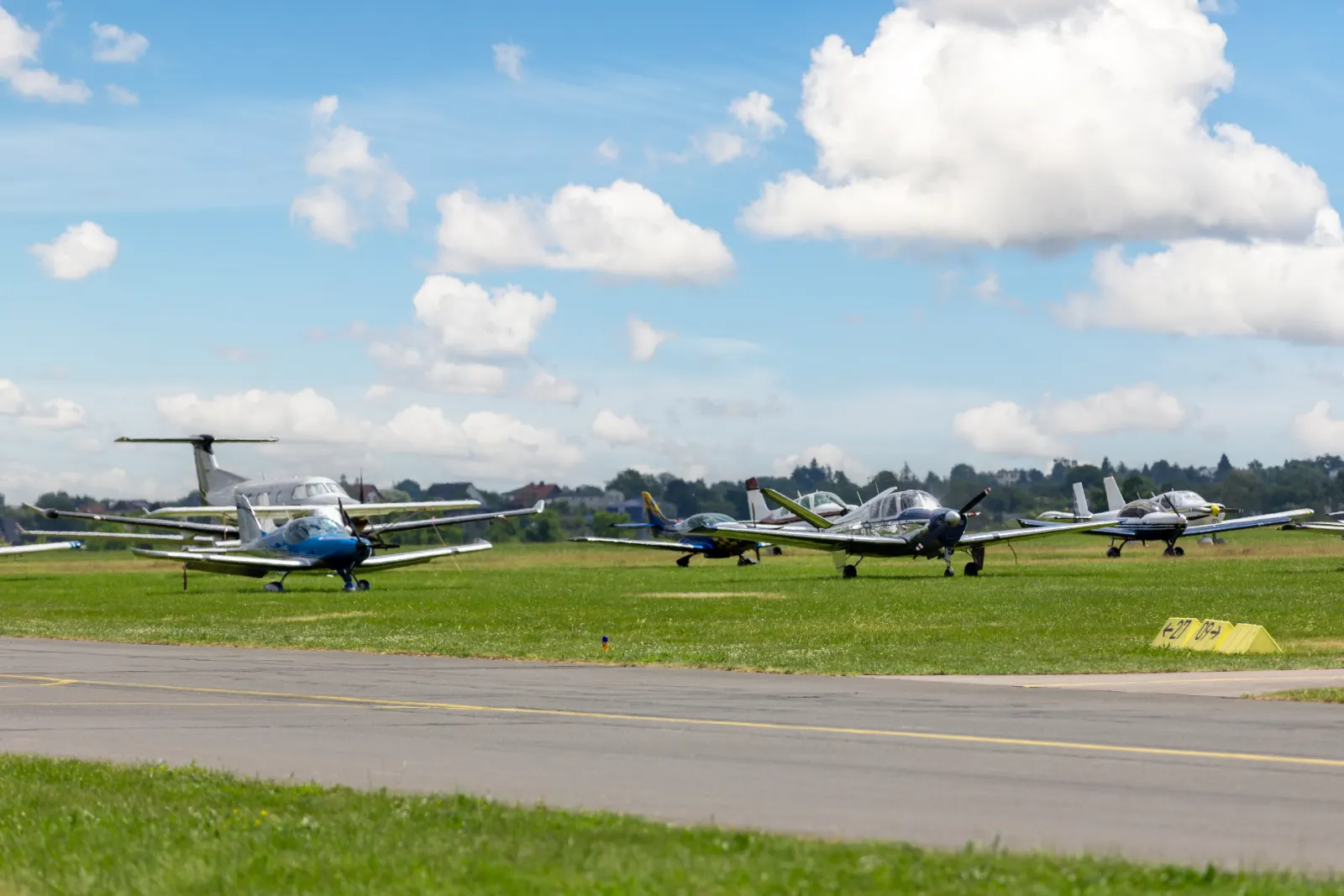 Aérodrome d’aviation générale : avions à pistons et turbopropulseur stationnés près de la piste