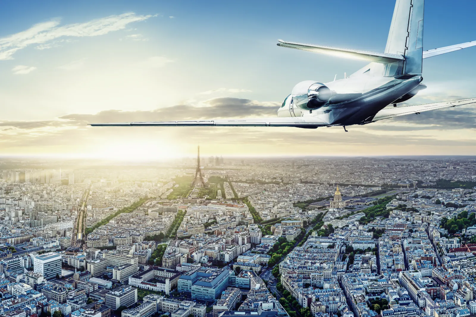 Location de jet privé à Paris : jet d’affaires survolant Paris et la tour Eiffel au coucher du soleil