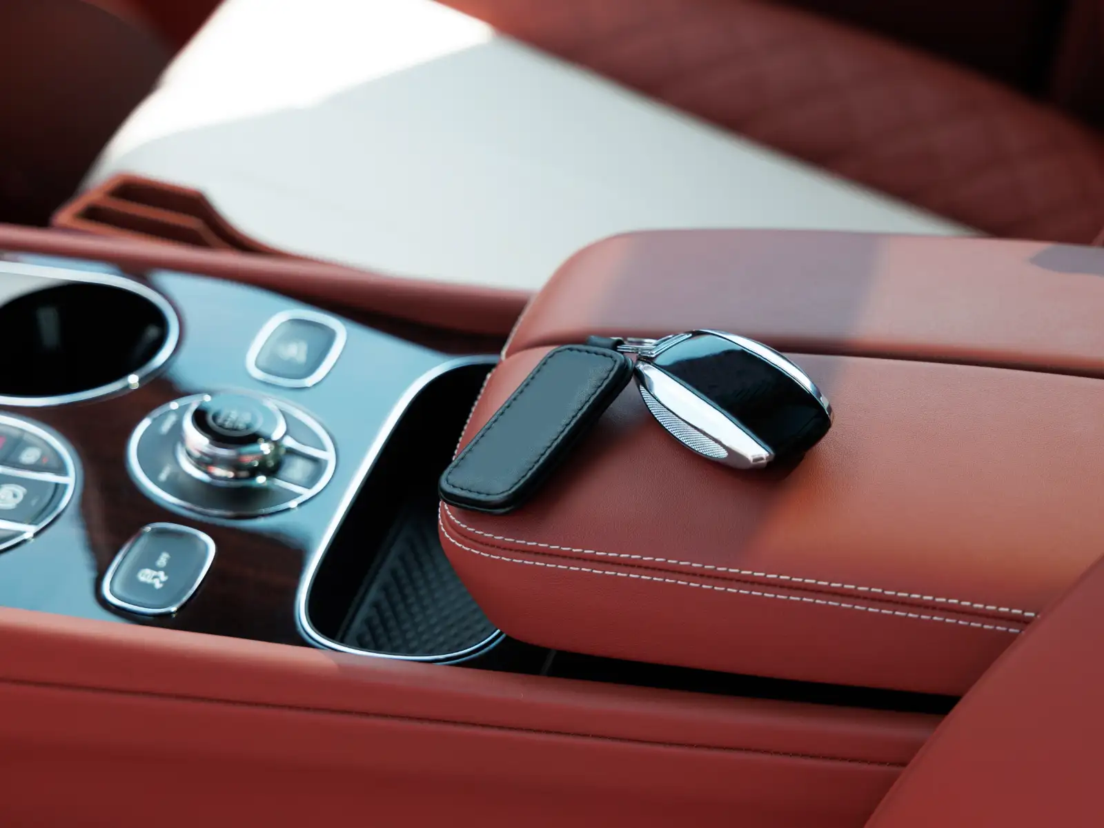 Location de voiture de luxe : clé et intérieur cuir cognac d’une berline de prestige